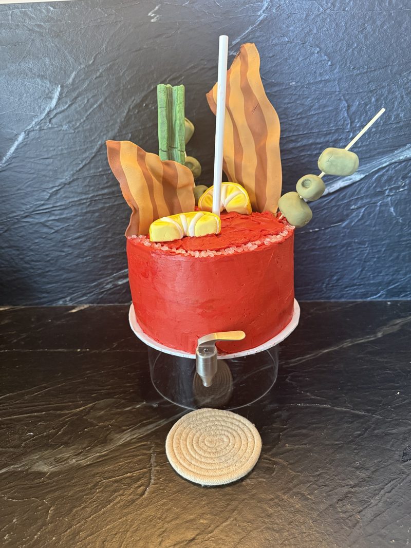 The Bloody Mary cake from the front, on a drink-dispenser stand with a steel tap
