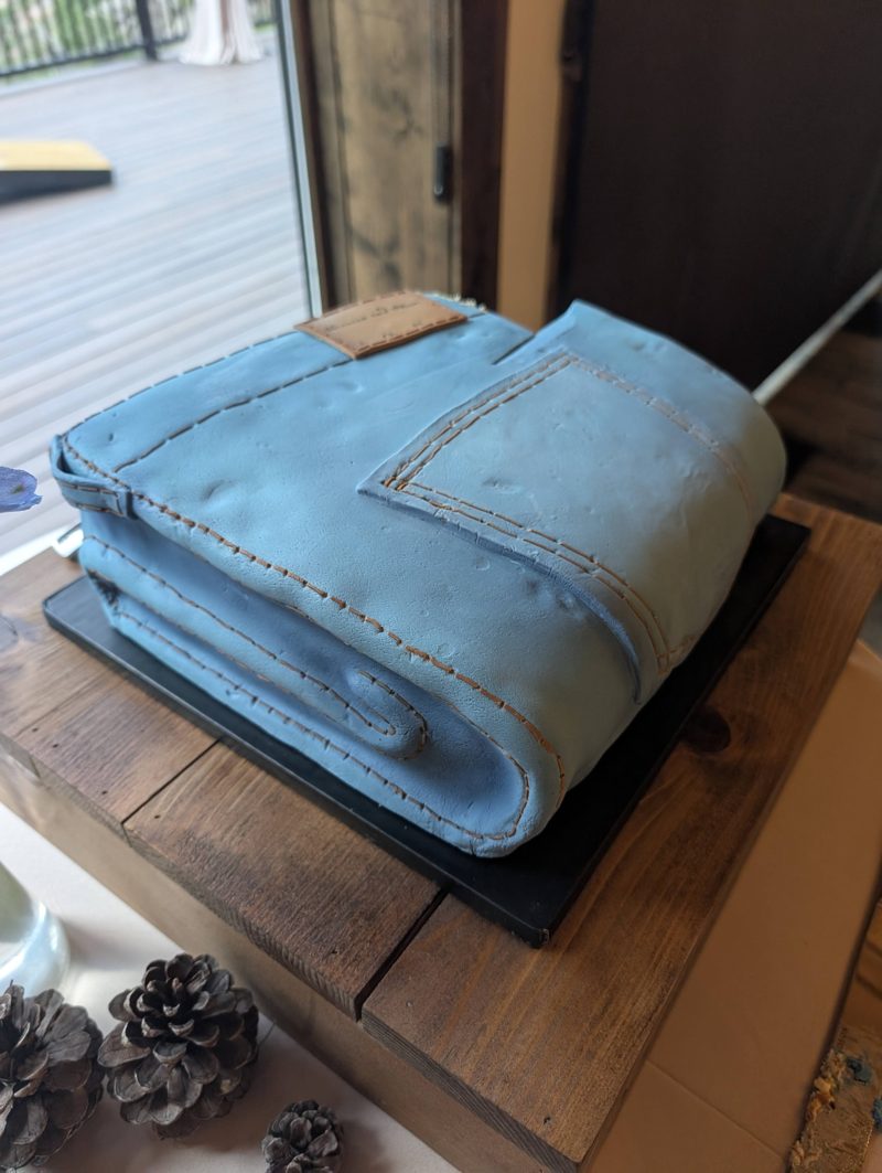 Wedding cake made to look like a folded pair of jeans, with stitched seams and a back pocket
